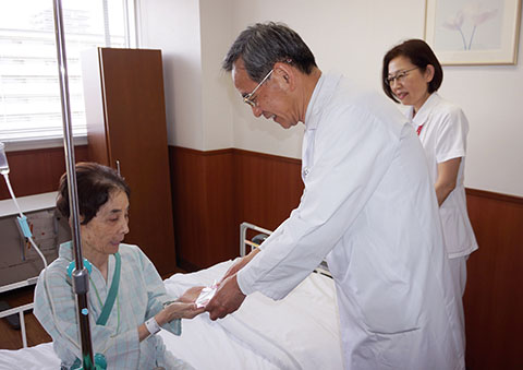 田内潤院長（右）から入院患者にメッセージカードと記念品が贈られた