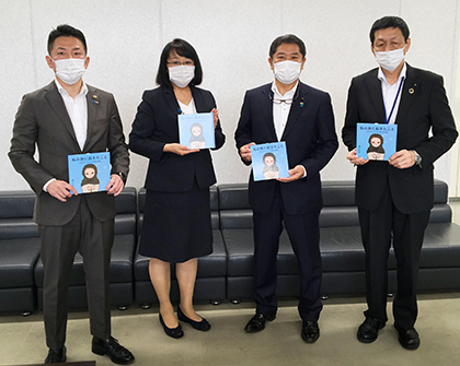 寄贈された絵本と西村日加留氏、安保智子氏、池尻秀樹氏、江戸善信氏（左から）